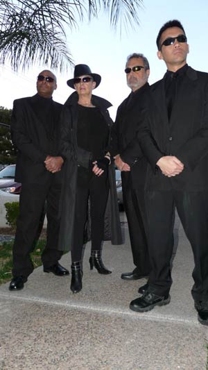 four people in black suits and sunglasses